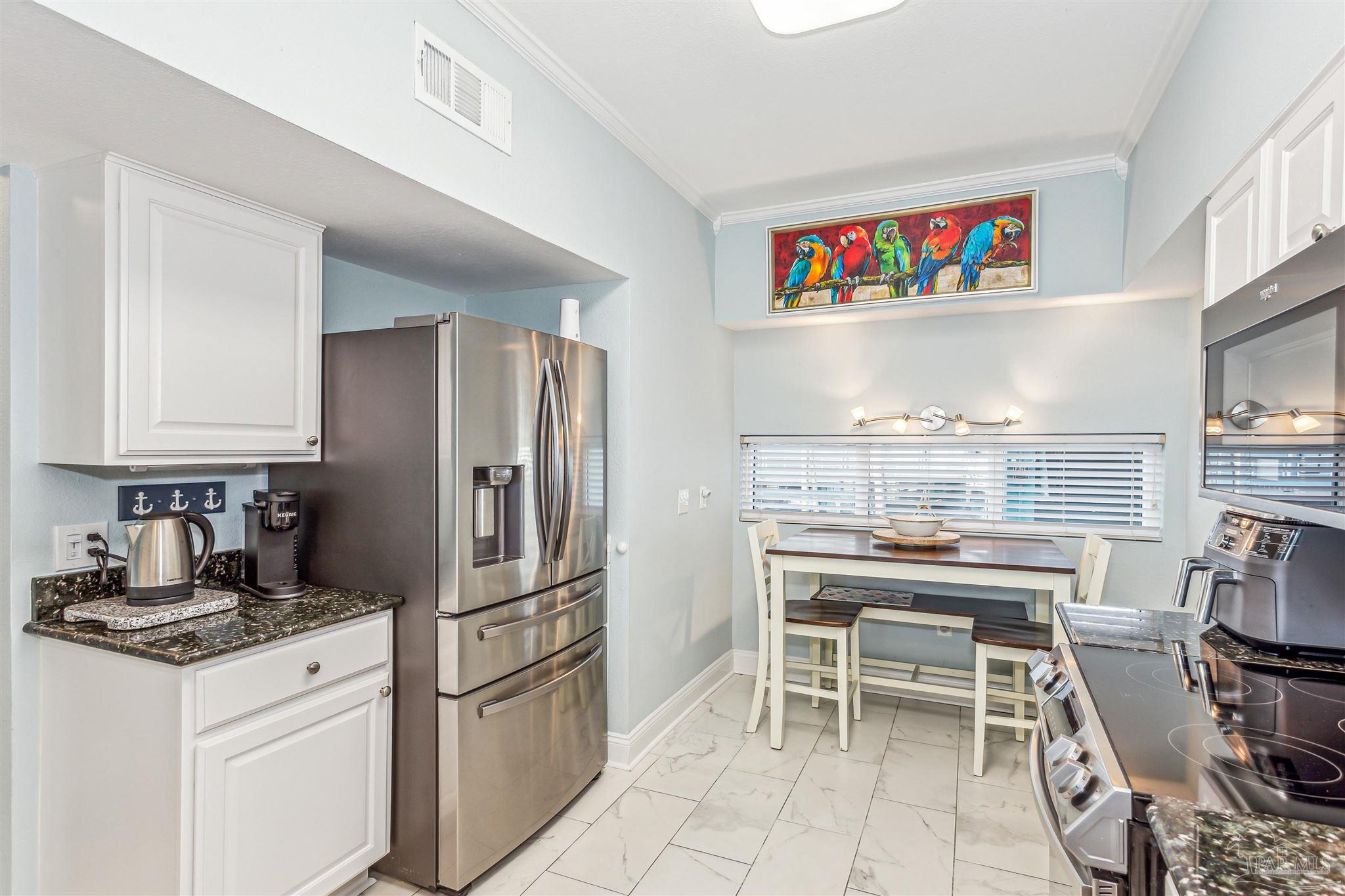 1390 Fort Pickens Road, Unit 116 Pensacola Beach, FL 32561 - Photo 18 of 37 a kitchen with stainless steel appliances granite countertop a refrigerator and a stove top oven