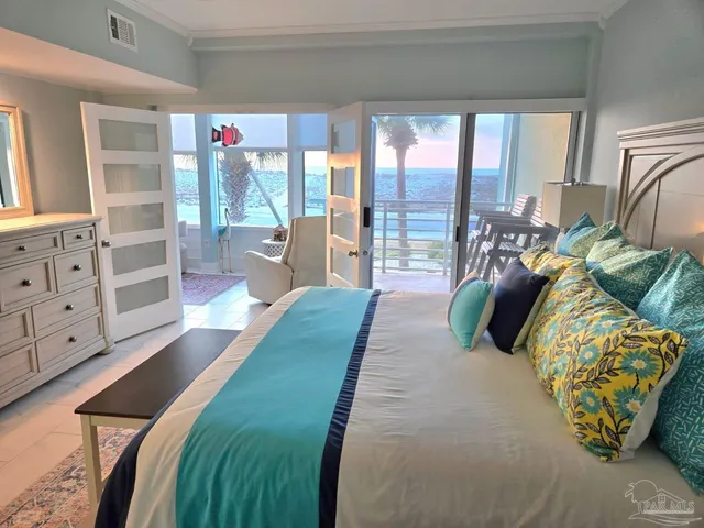 a spacious bedroom with a bed and glass walk in closet