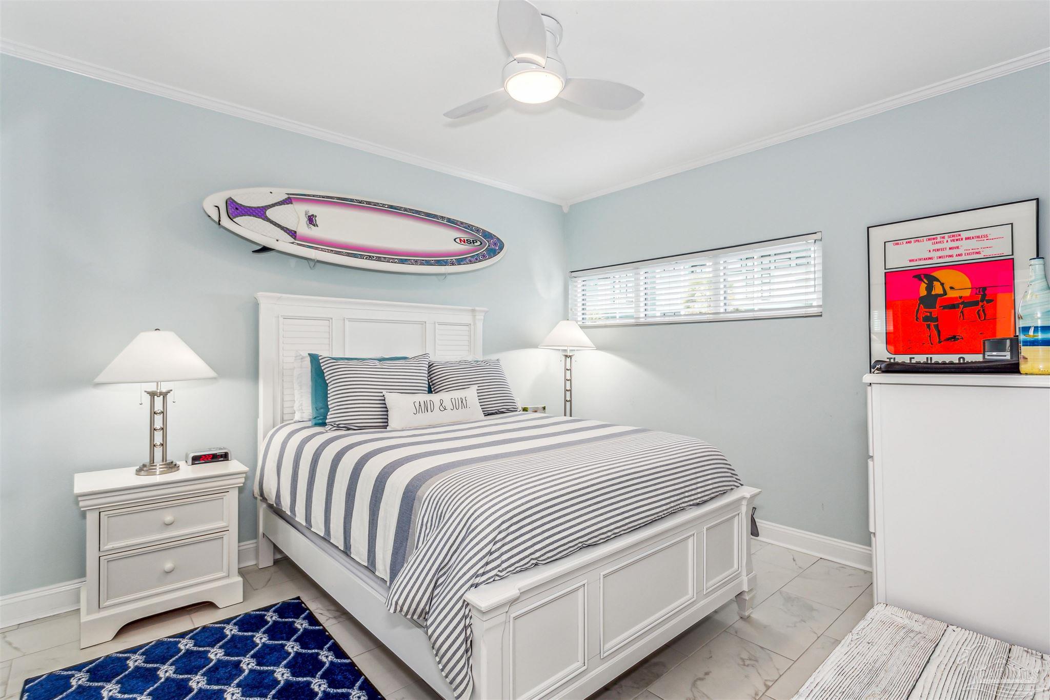 1390 Fort Pickens Road, Unit 116 Pensacola Beach, FL 32561 - Photo 27 of 37 a bedroom with a bed and a chandelier