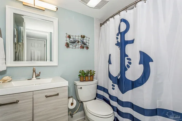 a bathroom with a toilet sink vanity and mirror