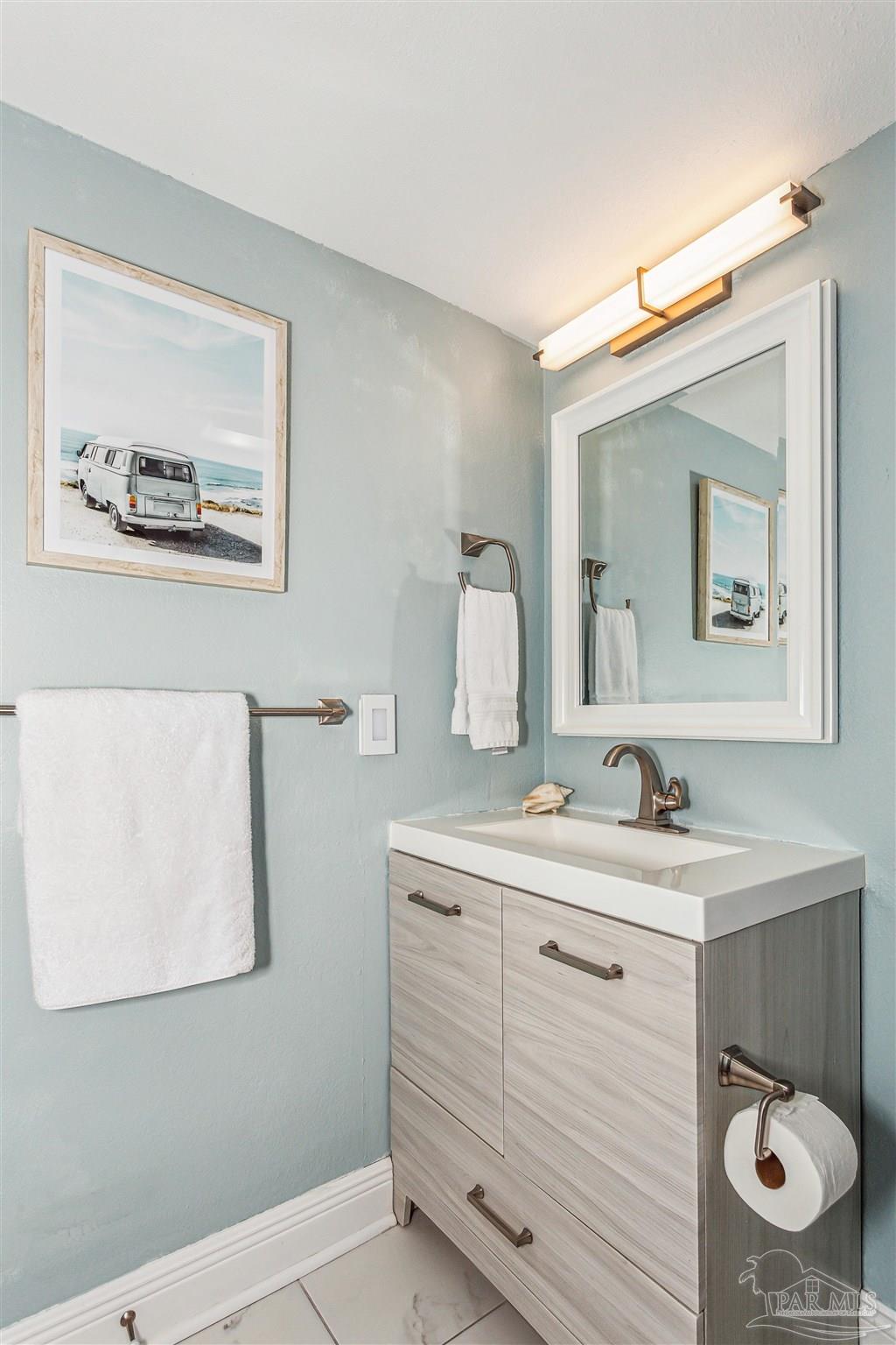 1390 Fort Pickens Road, Unit 116 Pensacola Beach, FL 32561 - Photo 30 of 37 a bathroom with a toilet a sink and mirror