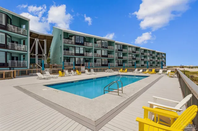 a view of swimming pool with outdoor seating and buildings in the background
