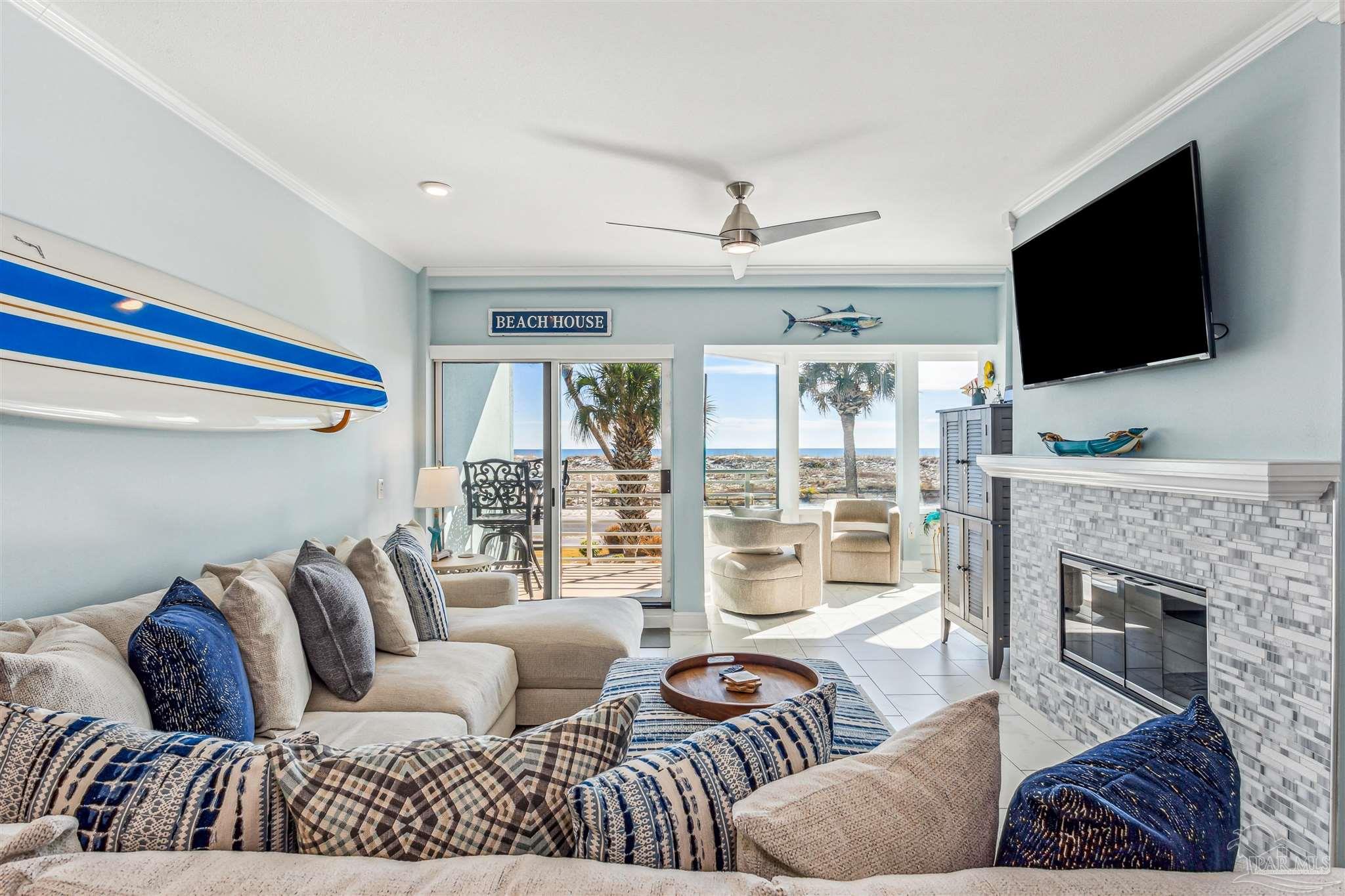 1390 Fort Pickens Road, Unit 116 Pensacola Beach, FL 32561 - Photo 8 of 37 a living room with furniture a flat screen tv and a fireplace