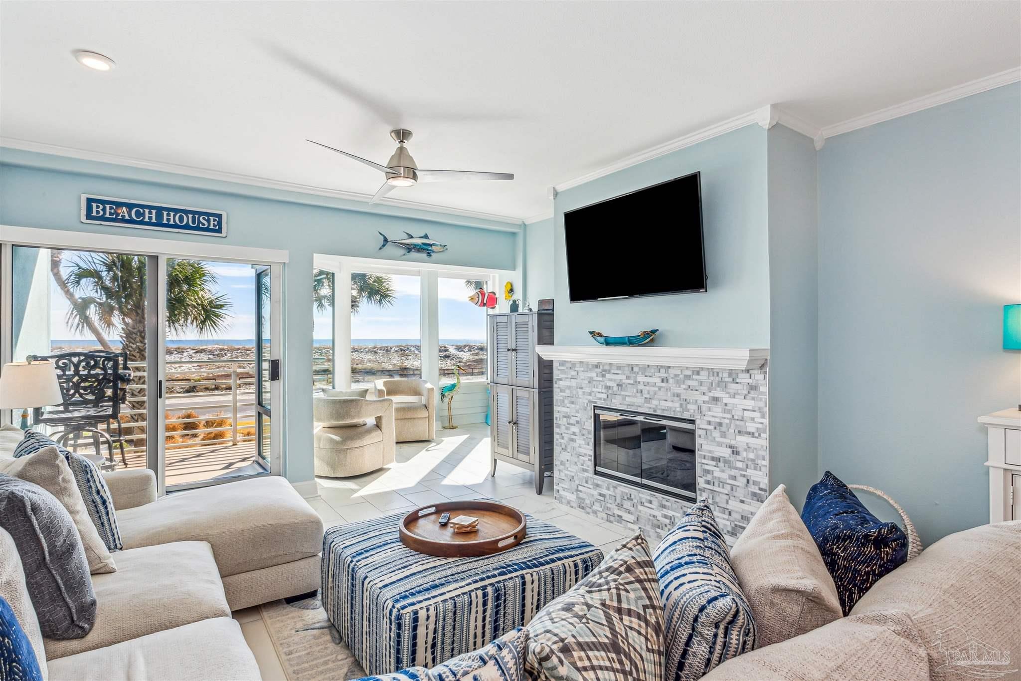 1390 Fort Pickens Road, Unit 116 Pensacola Beach, FL 32561 - Photo 9 of 37 a living room with furniture a fireplace and a flat screen tv