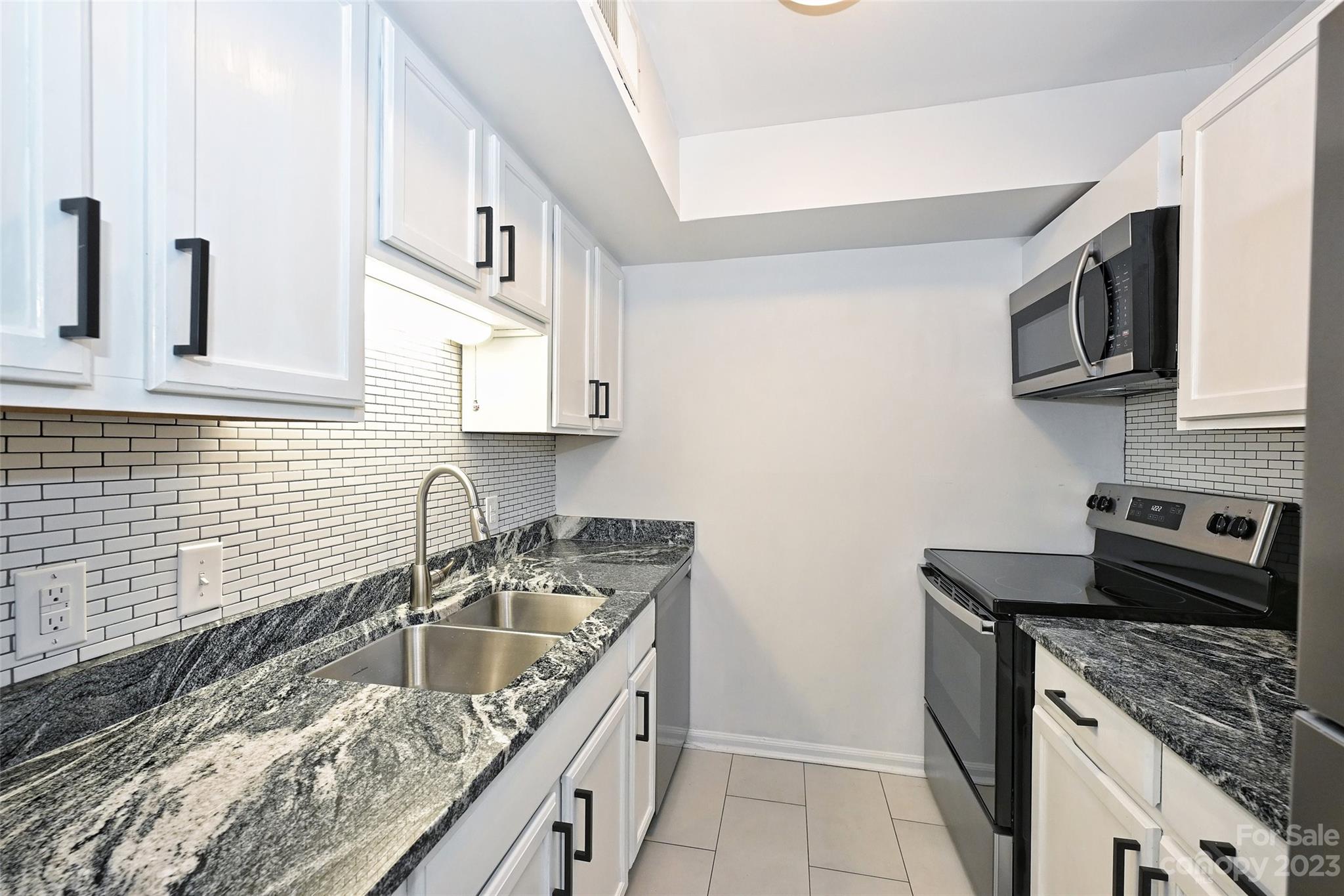 430 Queens Road, Unit 612 Charlotte, NC 28207 - Photo 12 of 22 a kitchen that has a sink and a stove