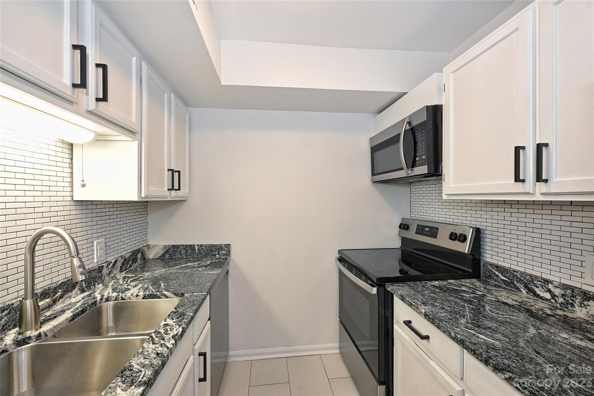 430 Queens Road, Unit 612 Charlotte, NC 28207 - Photo 13 of 22 a kitchen with stainless steel appliances granite countertop a sink stove and cabinets