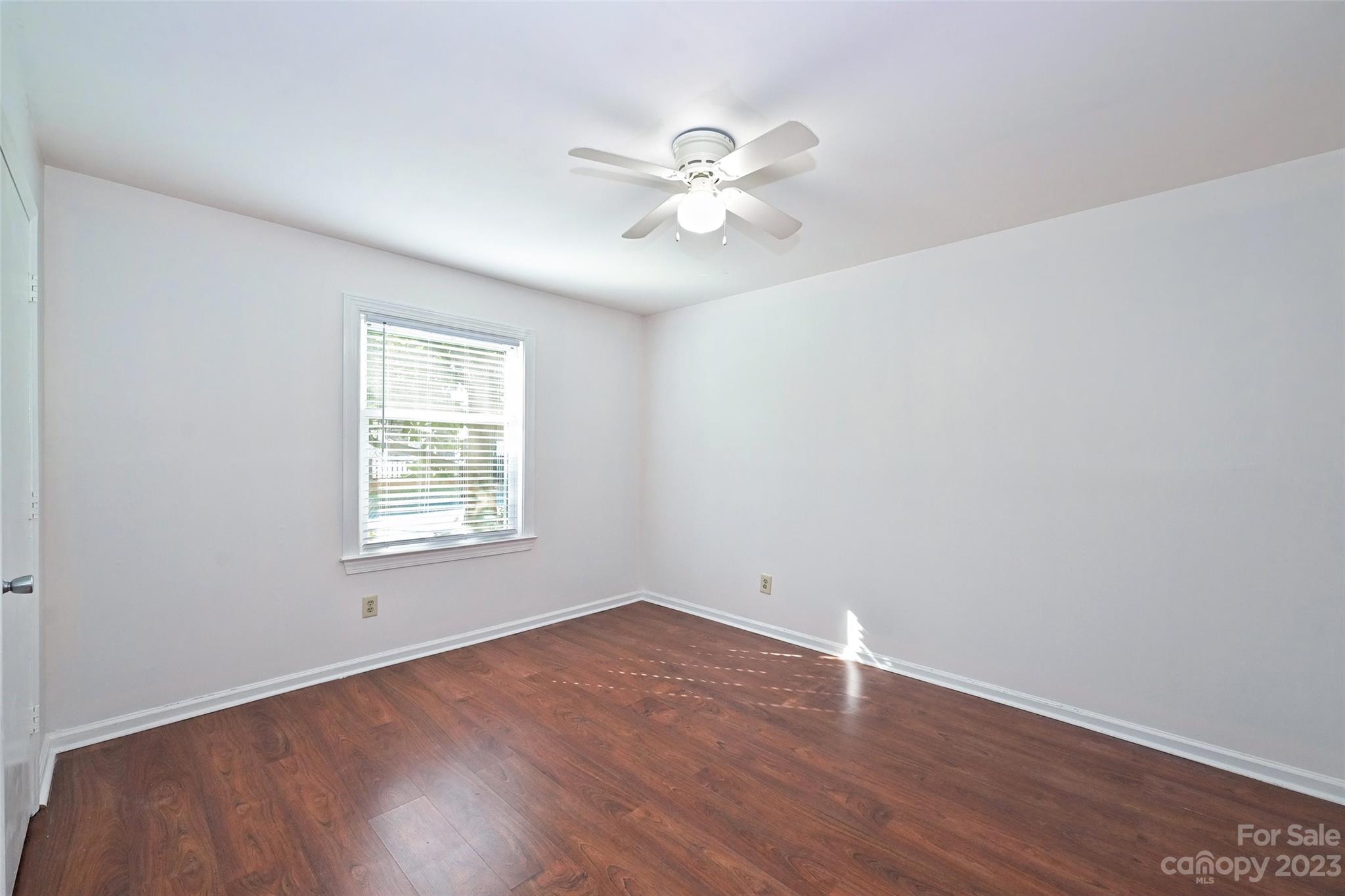 430 Queens Road, Unit 612 Charlotte, NC 28207 - Photo 17 of 22 an empty room with wooden floor fan and windows