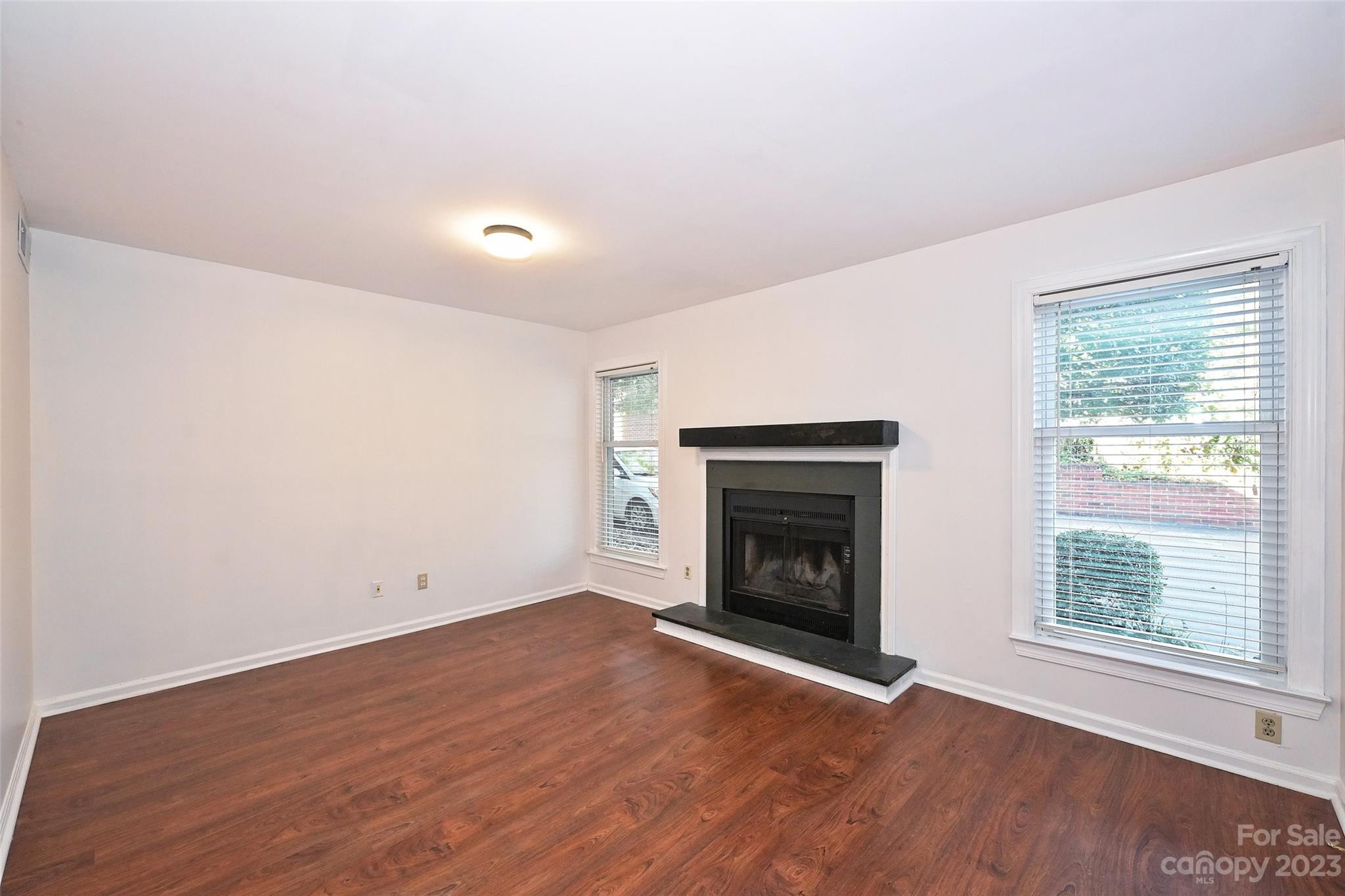 430 Queens Road, Unit 612 Charlotte, NC 28207 - Photo 4 of 22 an empty room with wooden floor fireplace and windows