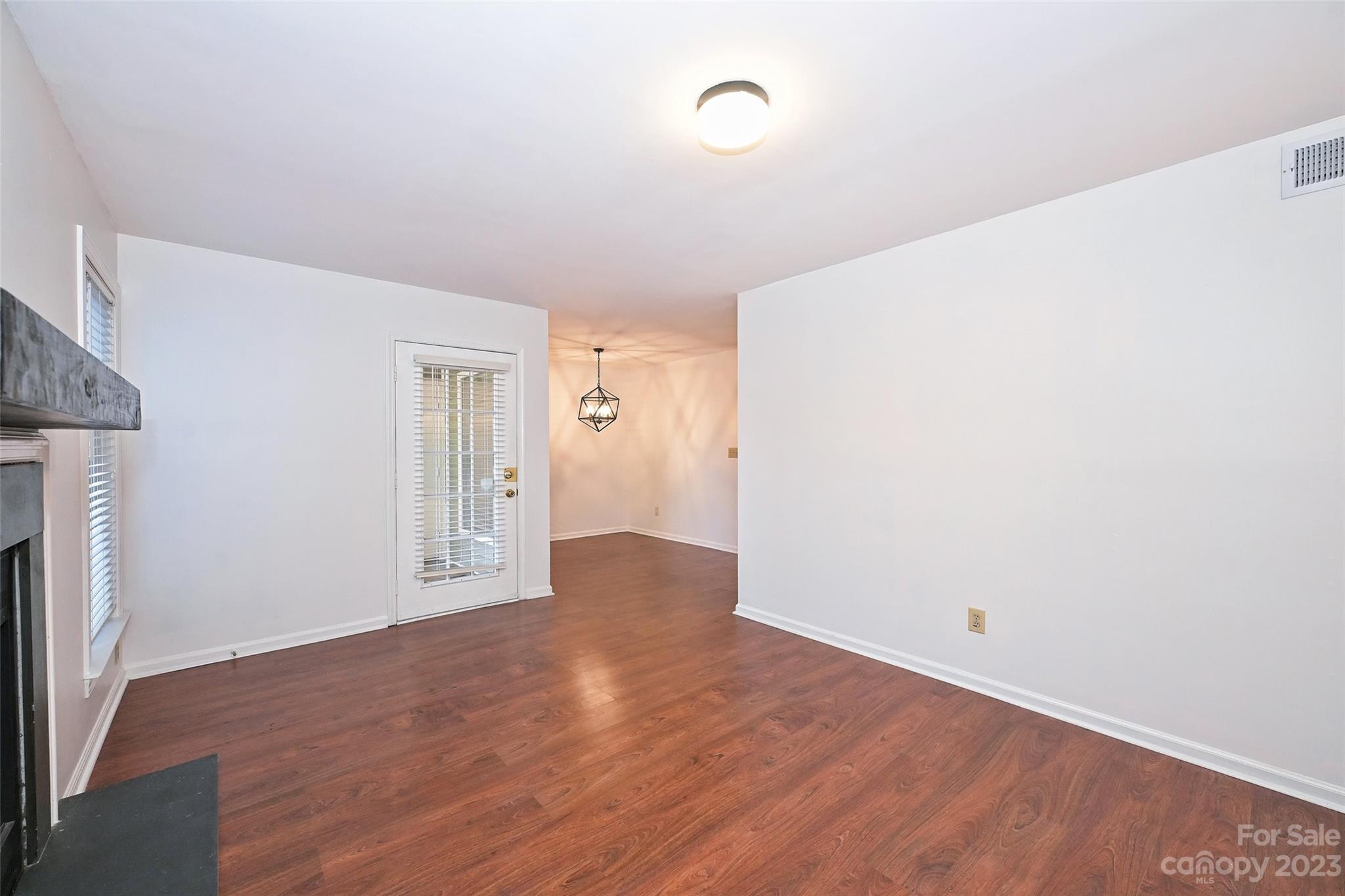 430 Queens Road, Unit 612 Charlotte, NC 28207 - Photo 7 of 22 an empty room with wooden floor and a fireplace