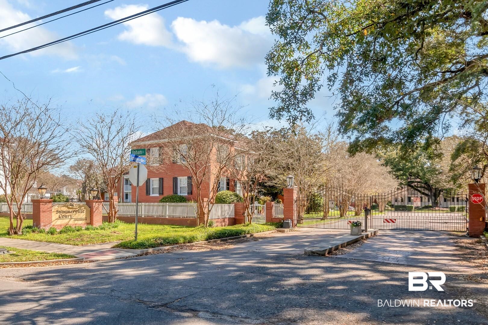 214 Upham Street, Unit 4A Mobile, AL 36607 - Photo 3 of 23 Exterior space with driveway, fence, brick siding, and a gate