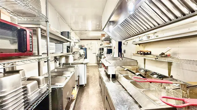 an open kitchen with stainless steel appliances granite countertop a stove and cabinets