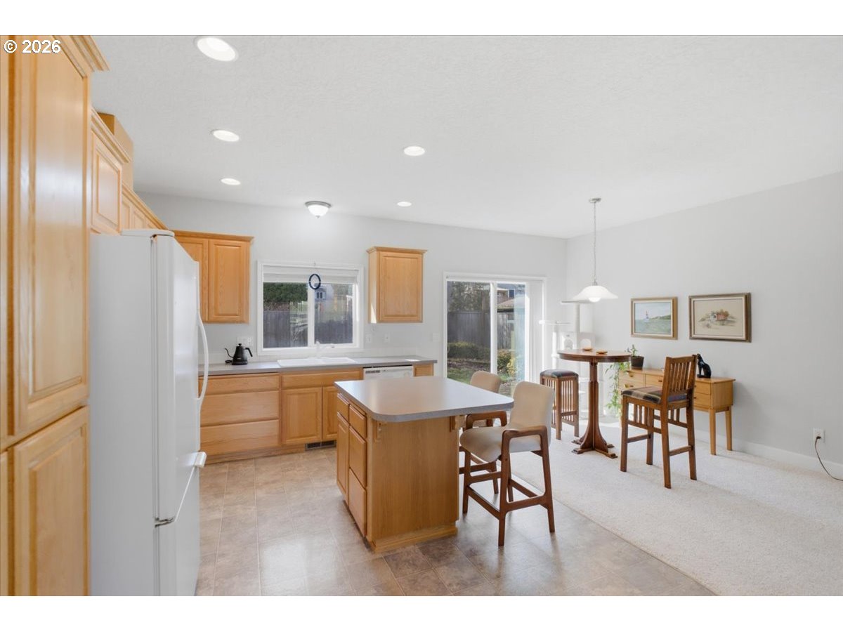 2066 Northwest Violet Avenue Albany, OR 97321 - Photo 14 of 48 a dining hall with stainless steel appliances granite countertop a refrigerator a sink a dining table and chairs with wooden floor