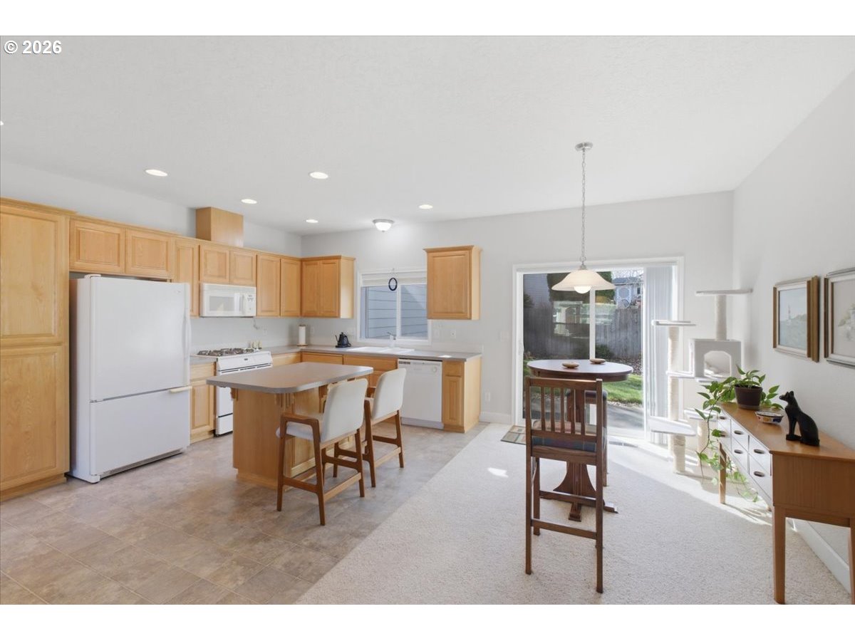 2066 Northwest Violet Avenue Albany, OR 97321 - Photo 15 of 48 a open kitchen with stainless steel appliances kitchen island granite countertop a table chairs and a refrigerator