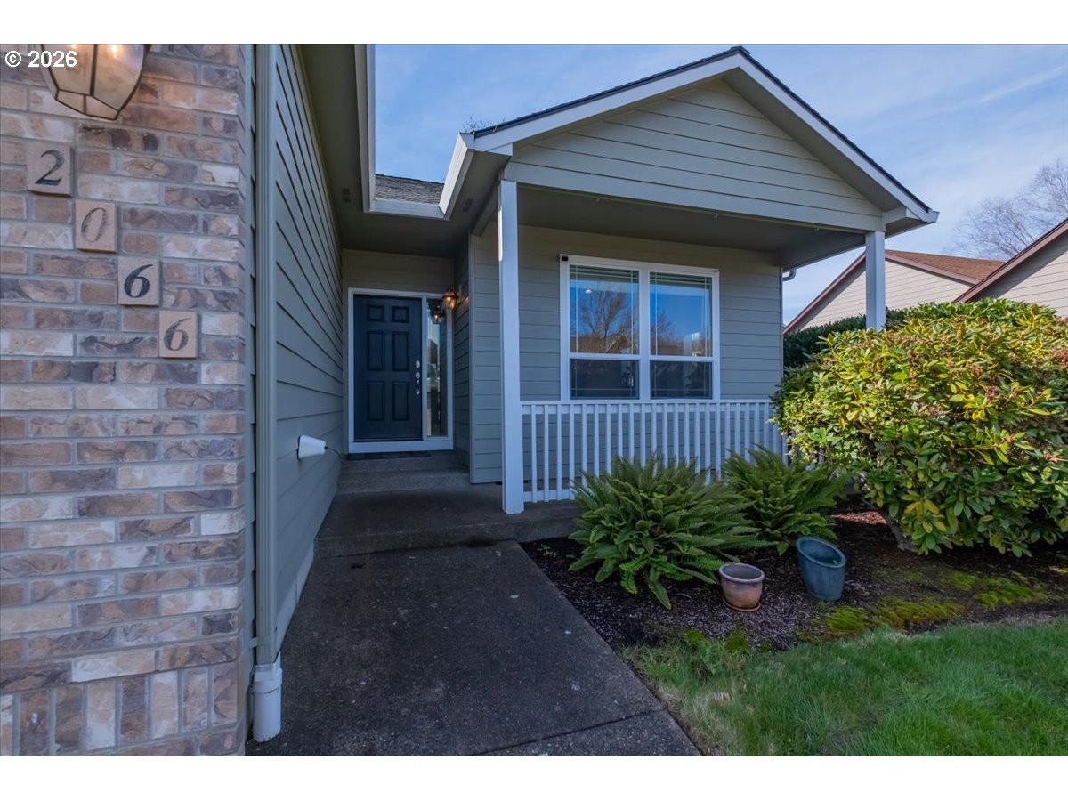 2066 Northwest Violet Avenue Albany, OR 97321 - Photo 4 of 48 a view of a brick house with a yard plants and large trees