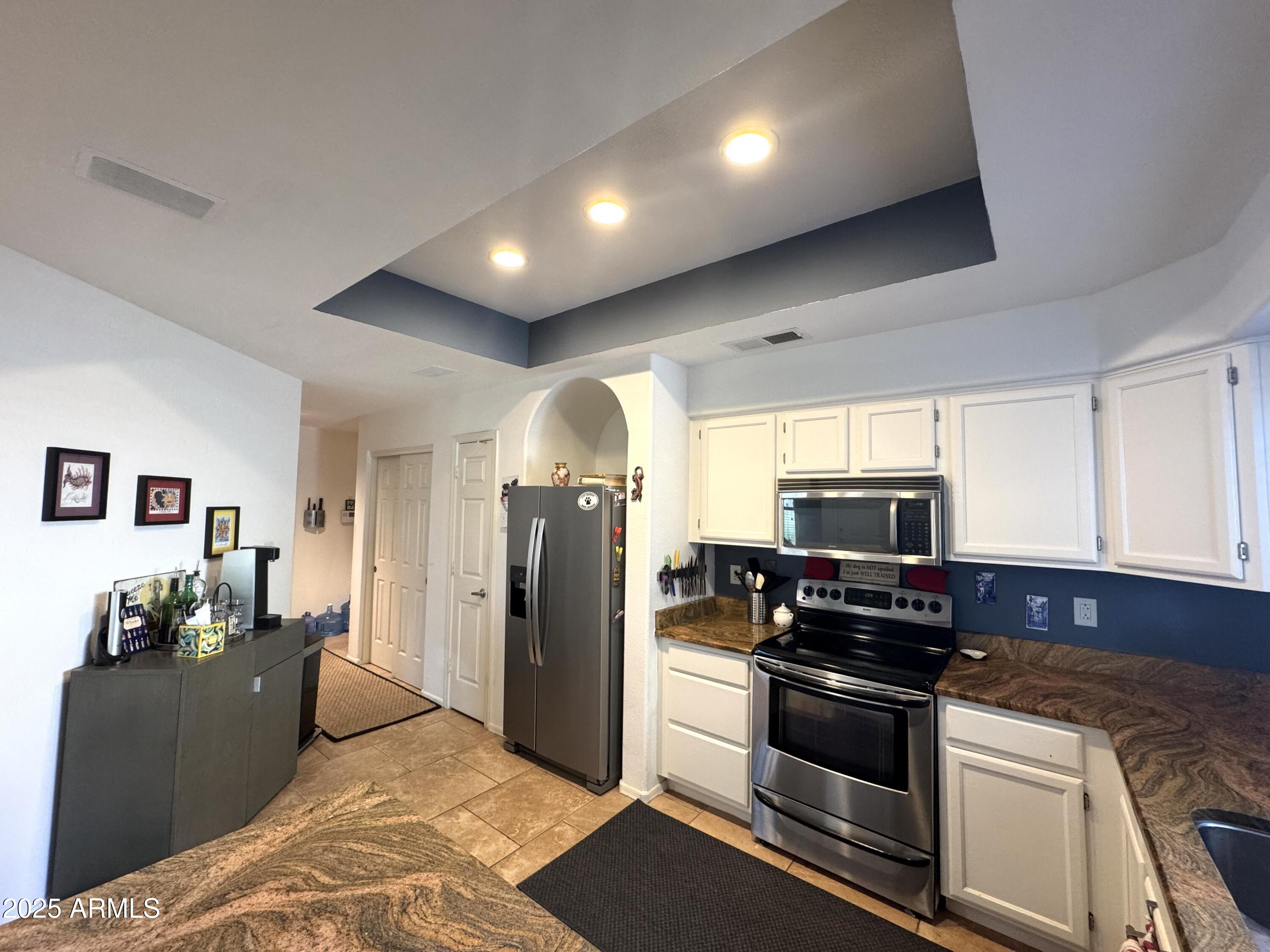 8833 South 51st Street, Unit 3 Phoenix, AZ 85044 - Photo 4 of 26 a kitchen with stainless steel appliances granite countertop a refrigerator and a stove top oven