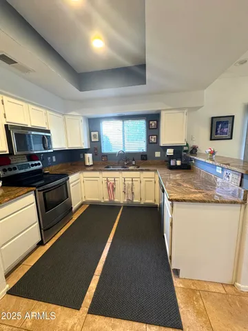 a kitchen with granite countertop a stove top oven a sink dishwasher and a microwave oven on the blue kitchen countertops