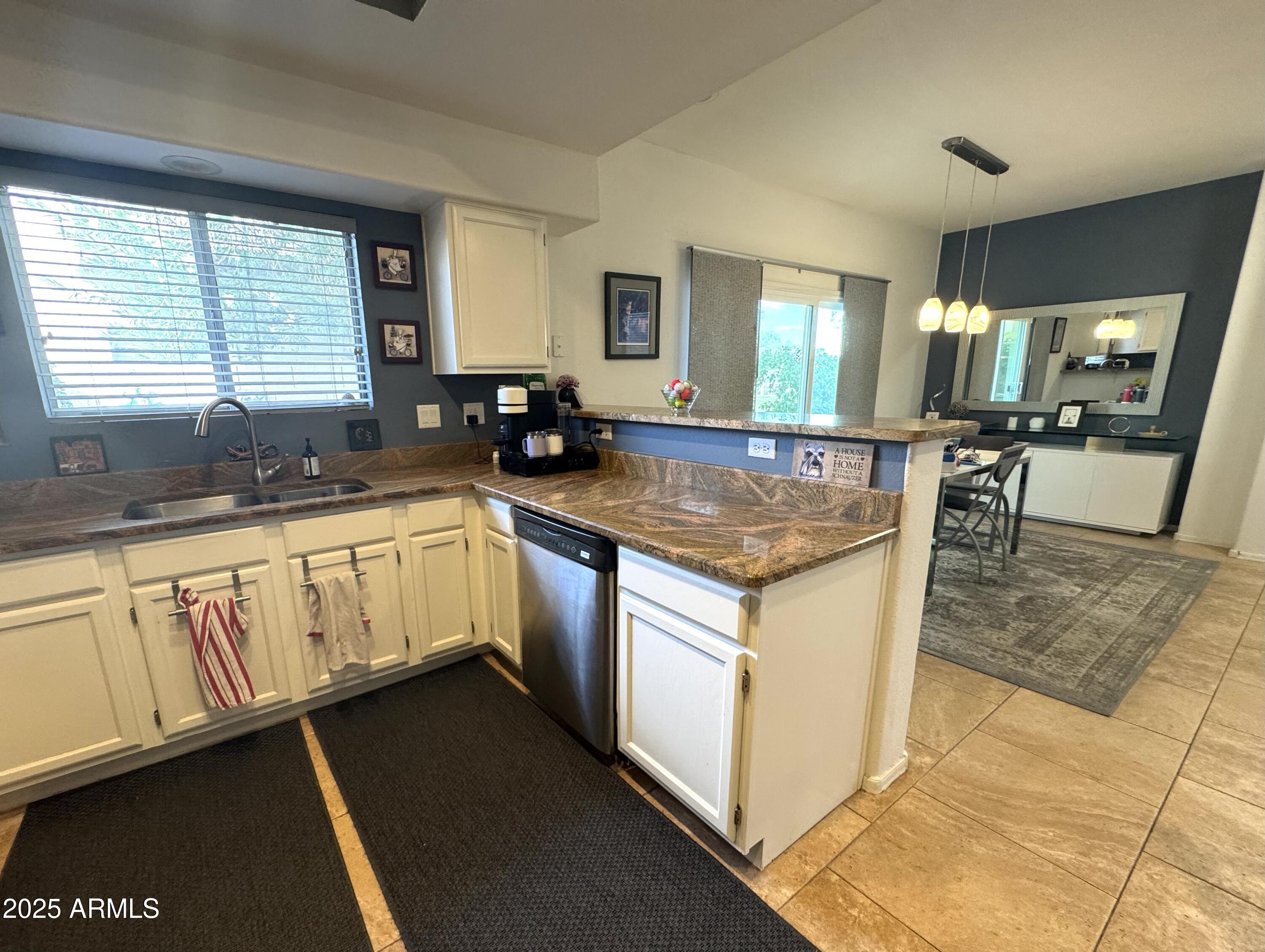 8833 South 51st Street, Unit 3 Phoenix, AZ 85044 - Photo 6 of 26 a kitchen with stainless steel appliances granite countertop a sink stove and cabinets