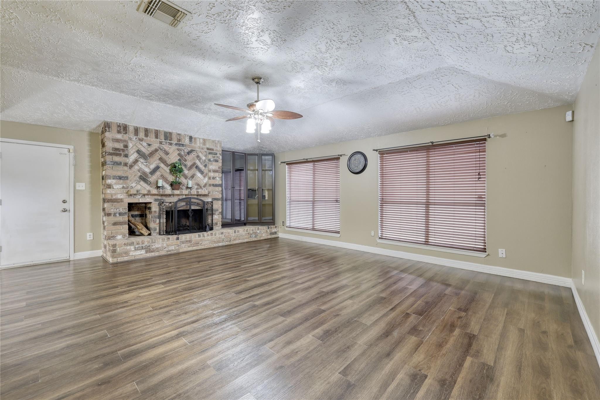 13331 Boyer Lane Houston, TX 77015 - Photo 11 of 21 an empty room with wooden floor fireplace and chandelier
