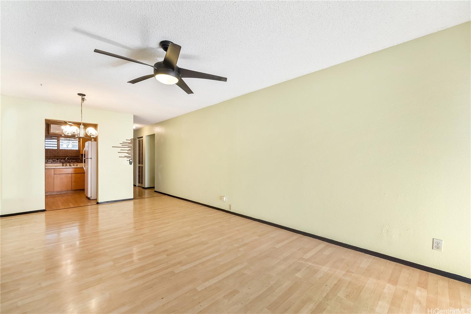 96-214 Waiawa Road, Unit 85 Pearl City, HI 96782 - Photo 3 of 10 a view of an empty room with wooden floor and a ceiling fan