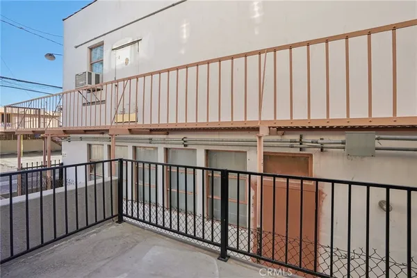 a view of staircase with lots of frames on wall and wooden floor