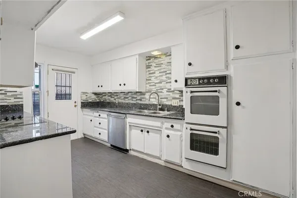 a kitchen with granite countertop cabinets stainless steel appliances and a counter space