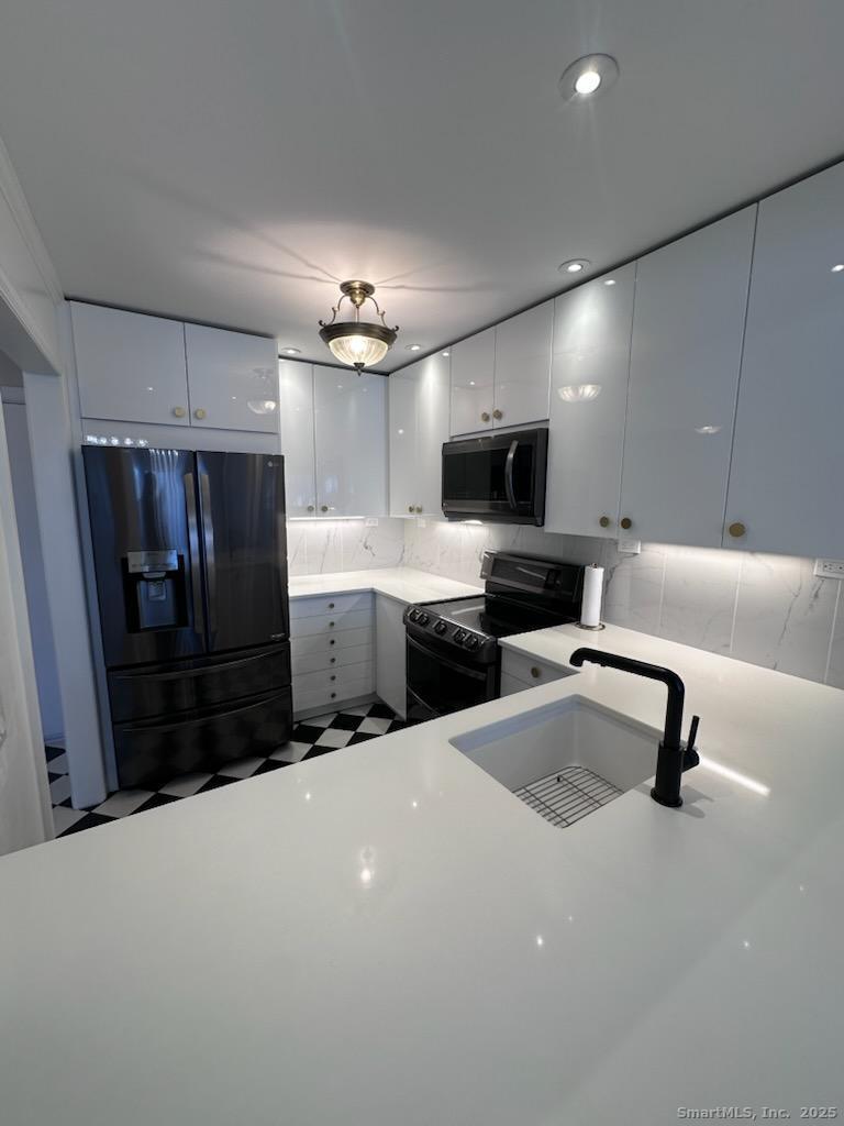 a kitchen with stainless steel appliances a refrigerator sink and microwave