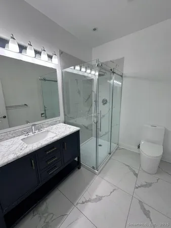 a bathroom with a double vanity sink mirror and toilet
