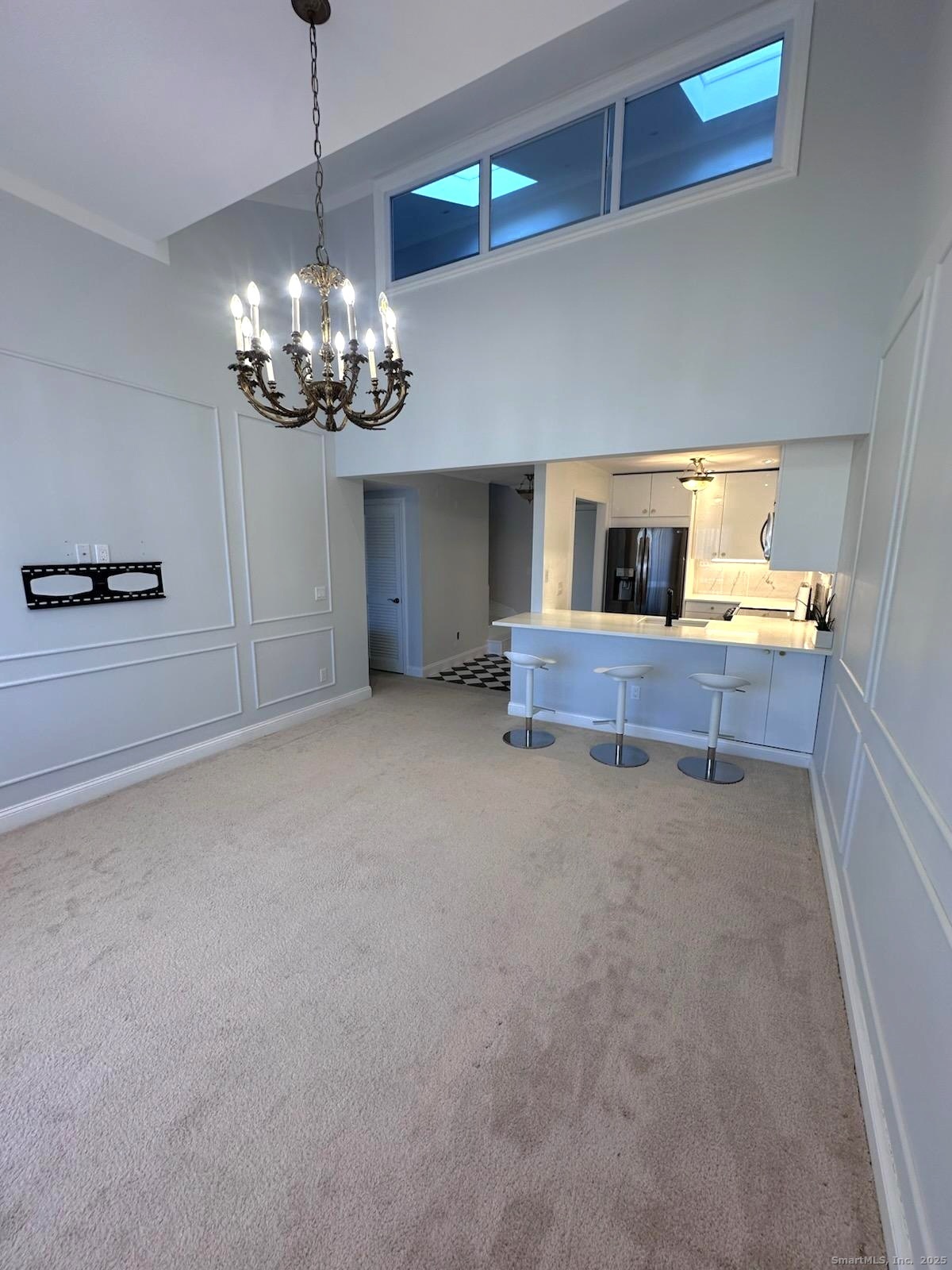 163 South Street, Unit 85 Danbury, CT 06810 - Photo 3 of 18 a view of a livingroom with a fireplace a kitchen sink and chandelier