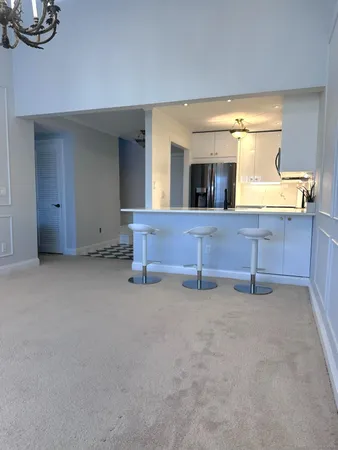 a view of an empty room with furniture and chandelier