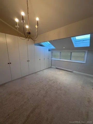 a view of an empty room with a chandelier fan
