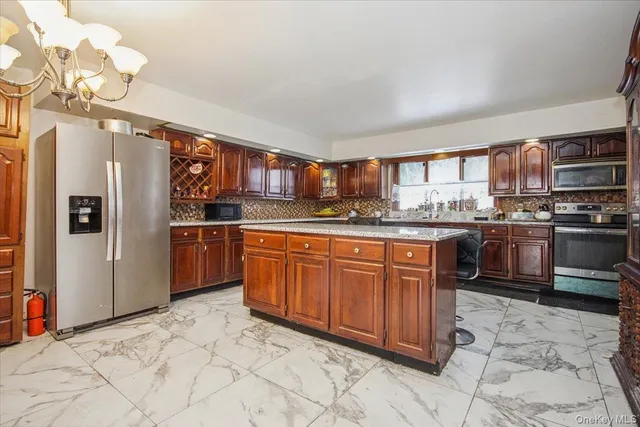 a kitchen with stainless steel appliances granite countertop a refrigerator and a stove top oven