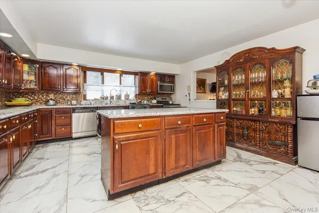a kitchen with stainless steel appliances granite countertop a stove a sink and a wooden cabinets