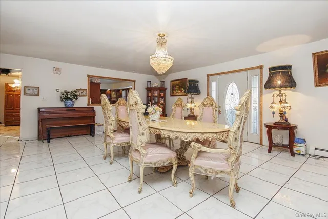 a dining room with wooden floor furniture and a chandelier