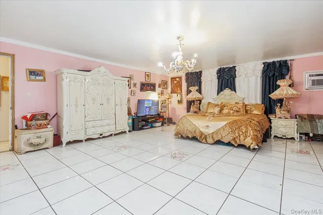 a spacious bedroom with a bed a lamp and a chandelier