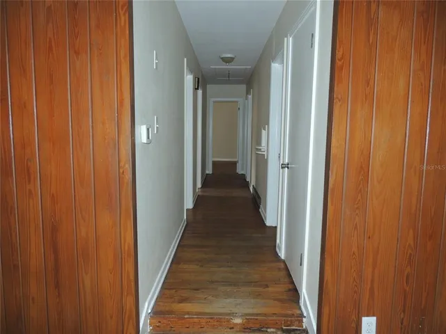 a view of a hallway with a wooden door