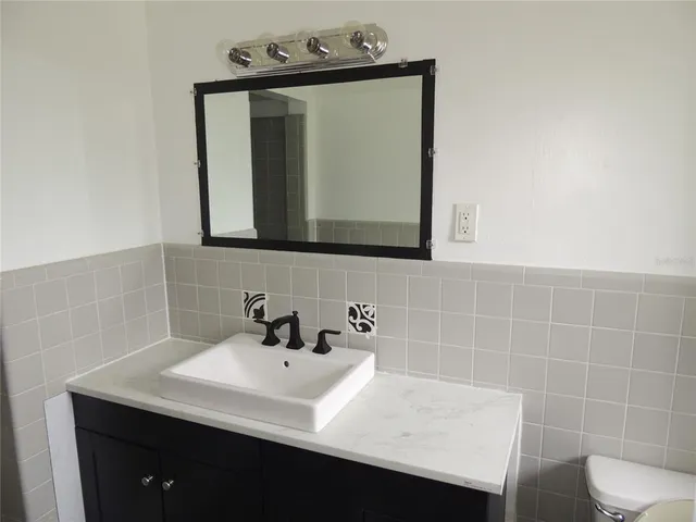 a bathroom with a sink a toilet and mirror