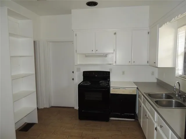 a kitchen with granite countertop white cabinets and refrigerator