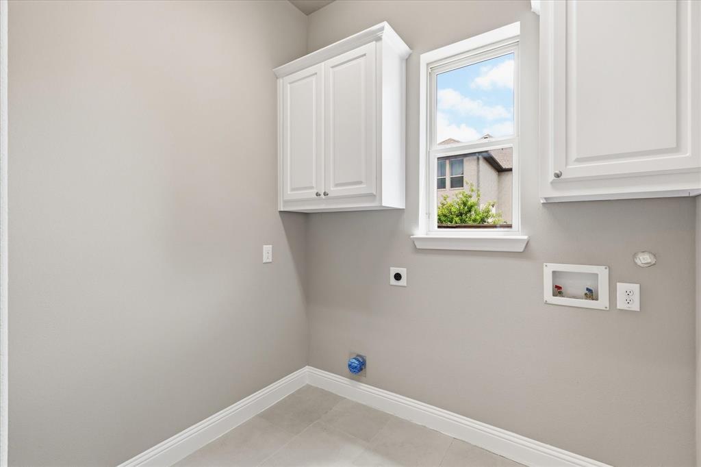 768 Huntingdon Street Coppell, TX 75019 - Photo 22 of 37 Bright laundry room with tile flooring, upper cabinetry, washer and dryer hookups, and a window for natural light.