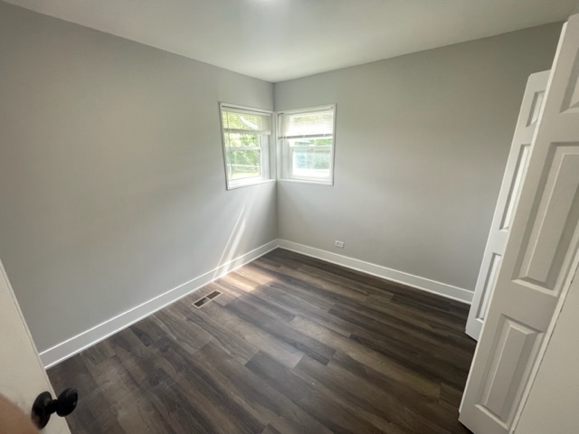 30 Apache Street Park Forest, IL 60466 - Photo 8 of 13 an empty room with wooden floor and windows