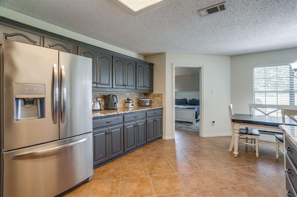 1050 Hampel Road Palmer, TX 75152 - Photo 19 of 35 a kitchen with stainless steel appliances granite countertop a refrigerator a stove a sink a dining table and chairs with wooden floor