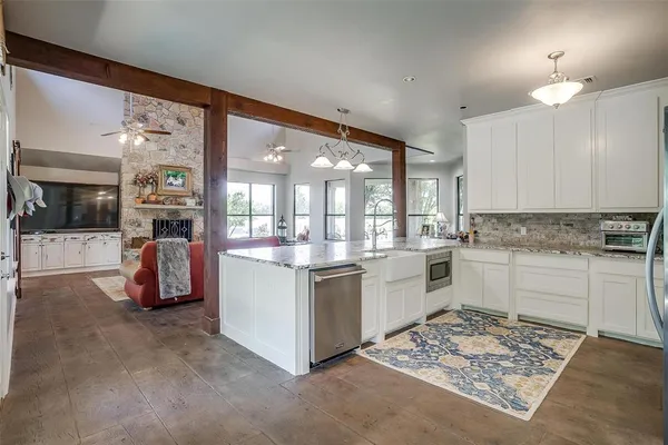 a large white kitchen with a sink and dishwasher stove
