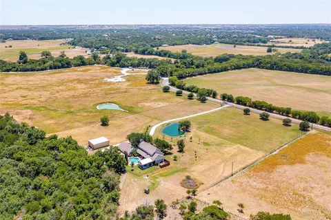 an aerial view of residential houses with outdoor space and river