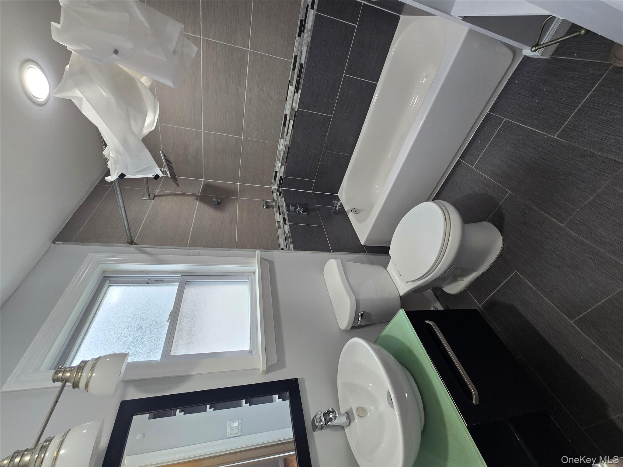 115-29 198th Street, Unit 1 Queens, NY 11412 - Photo 7 of 12 a bathroom with a sink toilet and shower