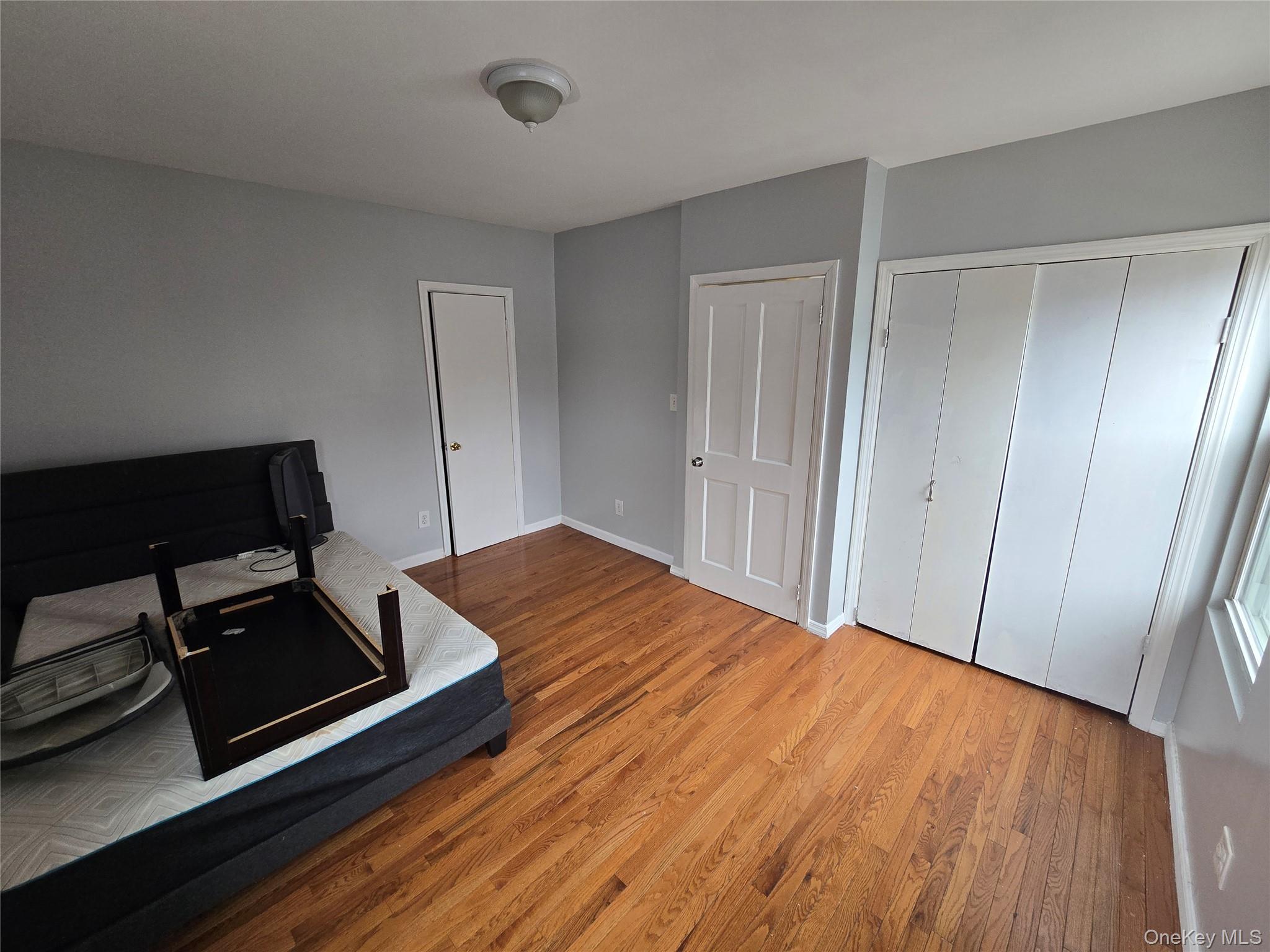 115-29 198th Street, Unit 1 Queens, NY 11412 - Photo 8 of 12 a room with a bed and wooden floor