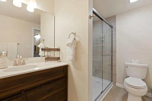 a bathroom with a sink a toilet and shower