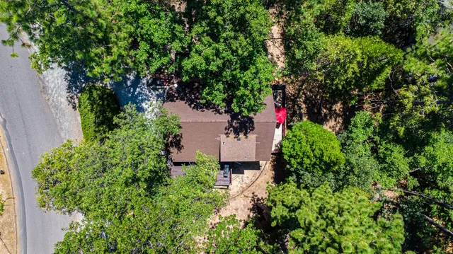 an aerial view of a house and trees all around