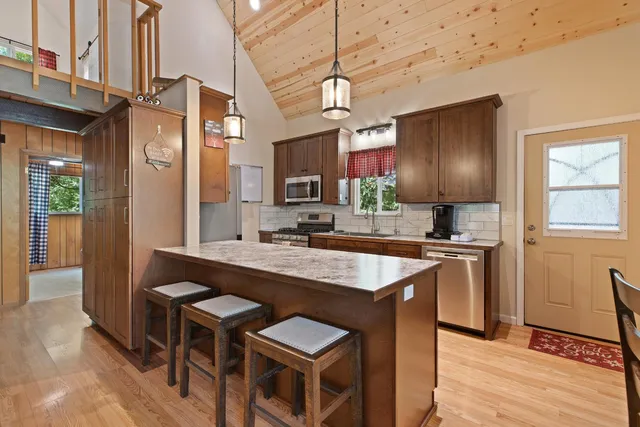 a kitchen with stainless steel appliances granite countertop a sink a stove and a refrigerator