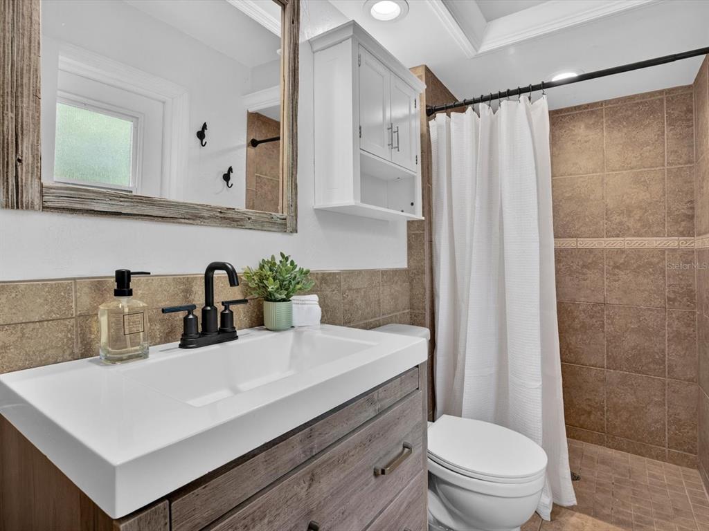 333 Cornwall Road Winter Park, FL 32792 - Photo 19 of 32 a bathroom with a sink a toilet a mirror and shower