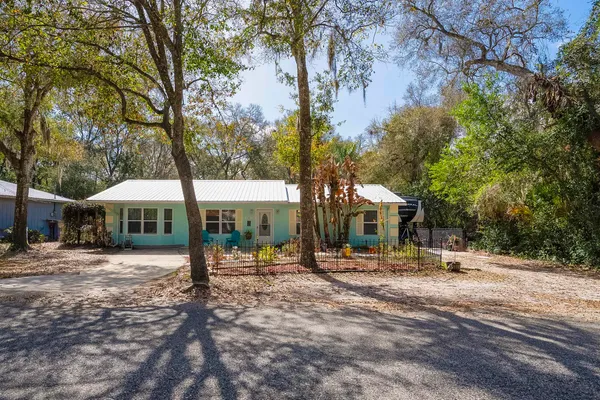 a front view of a house with a yard and tree s