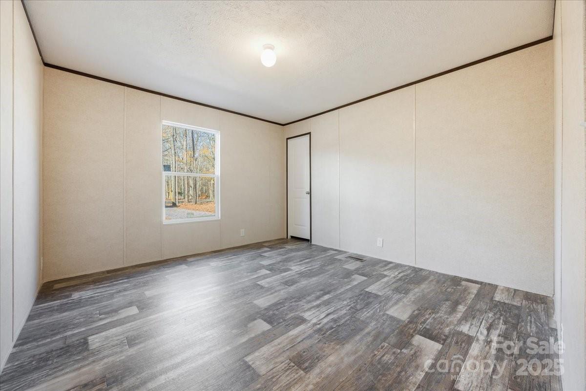 1381 Safrit Road Salisbury, NC 28146 - Photo 15 of 19 an empty room with wooden floor and windows